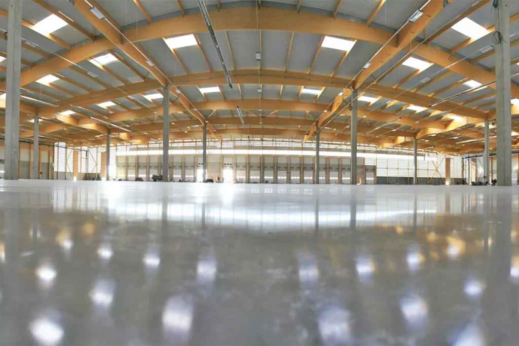พื้นโกดังที่ผ่านการแก้ไข ด้วยการใช้ น้ำยาบ่ม และเคลือบผิวคอนกรีต สีใส ช่วยลดการเกิดฝุ่น